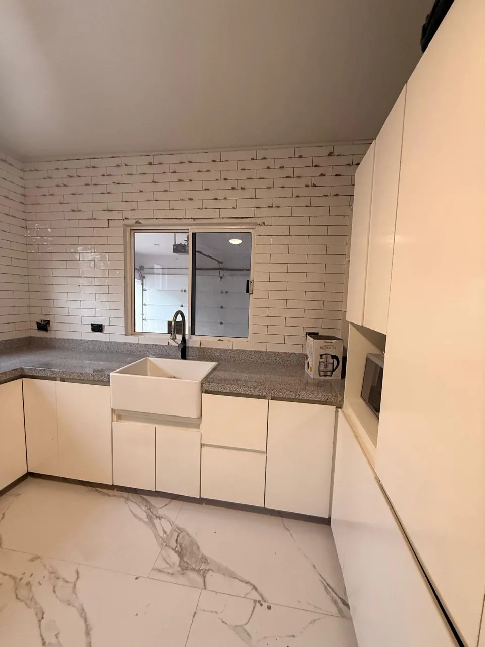 Cocina remodelada con azulejo subway blanco y gabinetes modernos — Level Up Construcción Monterrey